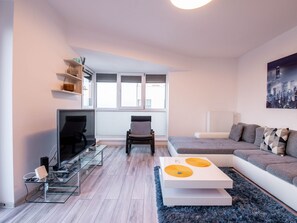 A modern living room with a glass coffee table, a sofa, a chair, and a fireplace. - Luxuriöse Präsidentensuite by Interhome (Bucuresti)