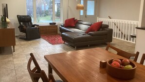 Un salon avec un canapé, une table à manger et un tapis rouge.