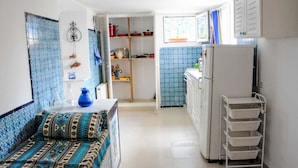 Eine kleine Küche mit Kühlschrank, Spüle und Fenster.