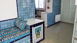 Eine Küche mit einem gemusterten Rückwand, einer weißen Arbeitsplatte und einem gefliesten Boden.