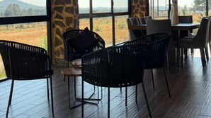 Comedor con vistas al paisaje, pilares de piedra y mobiliario moderno.