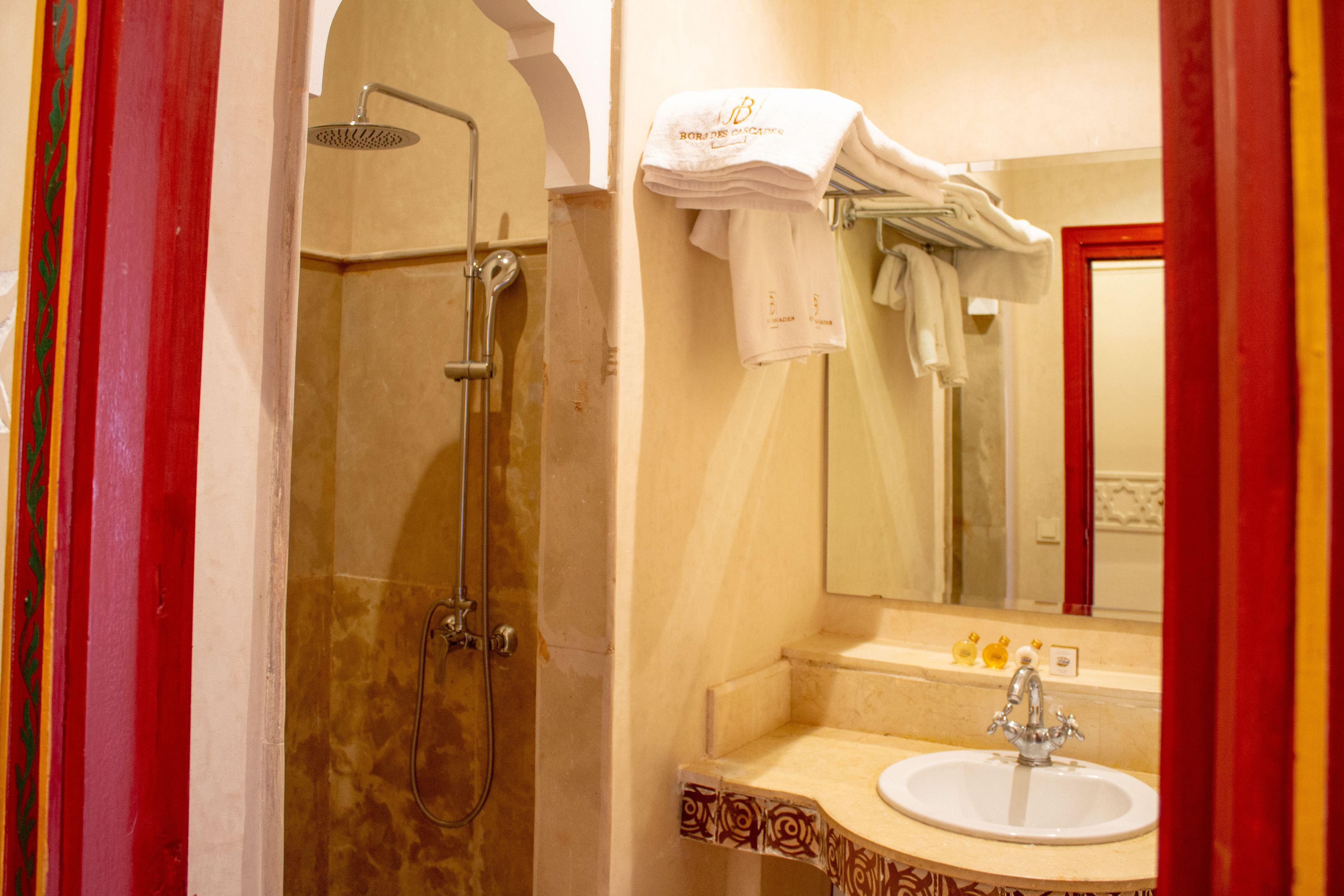 A bathroom with a shower, a sink, and a mirror.