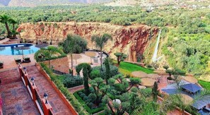 Ein Resort mit Schwimmbad, Sitzgelegenheiten im Freien und einem Wasserfall.