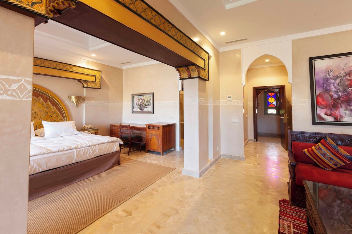 Una habitación de hotel con una cama, un escritorio y un sofá rojo.