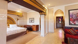 Une chambre d’hôtel avec un lit, un bureau et un canapé rouge.