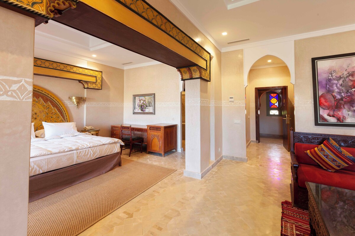 Ein Hotelzimmer mit Bett, Schreibtisch und einem roten Sofa.