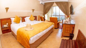 Une chambre d’hôtel avec un grand lit, un bureau, une chaise et une vue sur le balcon.