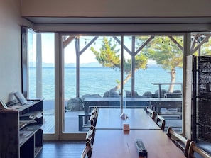Une salle de conférence avec vue sur la mer, de grandes fenêtres et une table en bois.