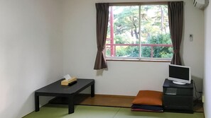 A room with a window, a desk, a chair, a TV, and a small table with a tissue box. - B B Dylan (Otsu)