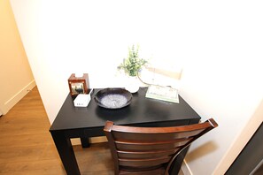A dining table with a vase of flowers, a bowl, and a menu. - NEW 6BR Bear Lake Home | 2 Min to Beach | Garage, Pool Access, Game Room | Sleeps 18 (Garden City)