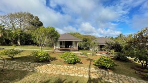 A house with a paved driveway and a lawn. - Fare Manini (Rimatara Island)