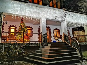 En bygning med et pyntet juletræ, sten trapper og et gelænder.