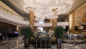 A spacious lobby with a grand chandelier, marble flooring, and a reception desk. - Guangzhou Vaperse Hotel Zhujiang Newtown (Guangzhou)