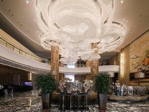 A spacious lobby with a grand chandelier, marble flooring, and a reception desk. - Guangzhou Vaperse Hotel Zhujiang Newtown (Guangzhou)