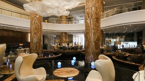 A spacious lobby with marble columns, modern seating, and a central water feature. - Guangzhou Vaperse Hotel Zhujiang Newtown (Guangzhou)
