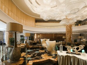 A spacious lobby with a high ceiling, elegant chandeliers, and a central seating area with modern chairs. - Guangzhou Vaperse Hotel Zhujiang Newtown (Guangzhou)