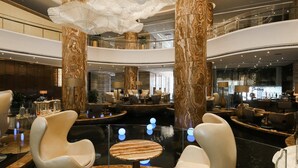 A spacious lobby with marble columns, modern seating, and a central water feature. - Guangzhou Vaperse Hotel Zhujiang Newtown (Guangzhou)