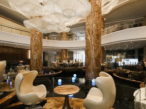 A spacious lobby with marble columns, modern seating, and a central water feature. - Guangzhou Vaperse Hotel Zhujiang Newtown (Guangzhou)