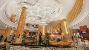A spacious lobby with a grand chandelier, marble columns, and a large mural. - Guangzhou Vaperse Hotel Zhujiang Newtown (Guangzhou)