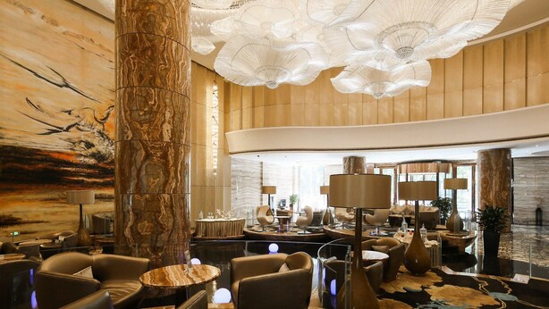 A spacious lobby with a high ceiling, marble columns, and modern seating areas. - Guangzhou Vaperse Hotel Zhujiang Newtown (Guangzhou)