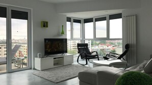 A modern living room with a flat-screen TV, a sofa, a coffee table, and a chair. There is a large window with a view of buildings outside. - Luxus-Residenz Westpark 2 by Interhome (Bucuresti)