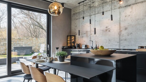 A modern kitchen with a large island, black chairs, and a hanging pendant light. - Exklusive Villa mit Swimmingpool und Whirlpool by Interhome (Varna)