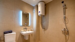 Une salle de bain moderne équipée de toilettes, d’un lavabo et d’une douche.