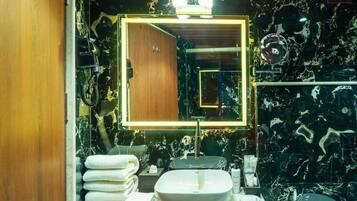 A bathroom with a marble sink, a large mirror, and a towel rack.