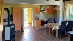 A spacious kitchen with a dining area, featuring a stove, oven, and a large window.
