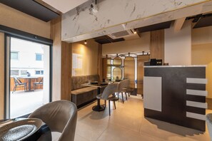 A modern dining area with a booth seating arrangement, a counter with a 'TIP BOX', and a view of the outside. - Taksim YEZ Hotel (Istanbul)
