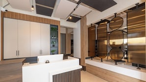 A modern reception area with a wooden reception desk, a large white cabinet, and decorative metal panels. - Taksim YEZ Hotel (Istanbul)