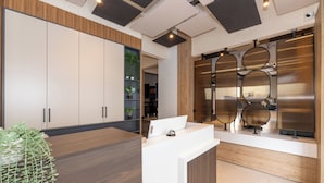 A modern reception area with a wooden reception desk, a potted plant, and a view into the adjacent room. - Taksim YEZ Hotel (Istanbul)