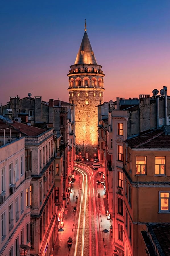 A historic tower with a conical roof, surrounded by buildings with visible windows and streetlights. - Taksim YEZ Hotel (Istanbul)