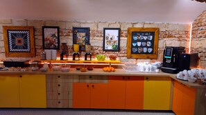 Una barra de desayuno con máquinas de café, un menú en pizarra y diferentes opciones de comida.