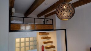 A room with a loft bed, a hanging light fixture, and built-in shelves. - Hotel S42 (Prague)