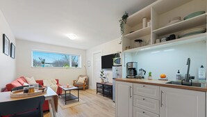A compact living space with a kitchenette, a dining area, and a seating area with a sofa and chairs. - Modern, Quiet, Fully Furnished Suite in the Heart of Lower Lonsdale (North Vancouver)