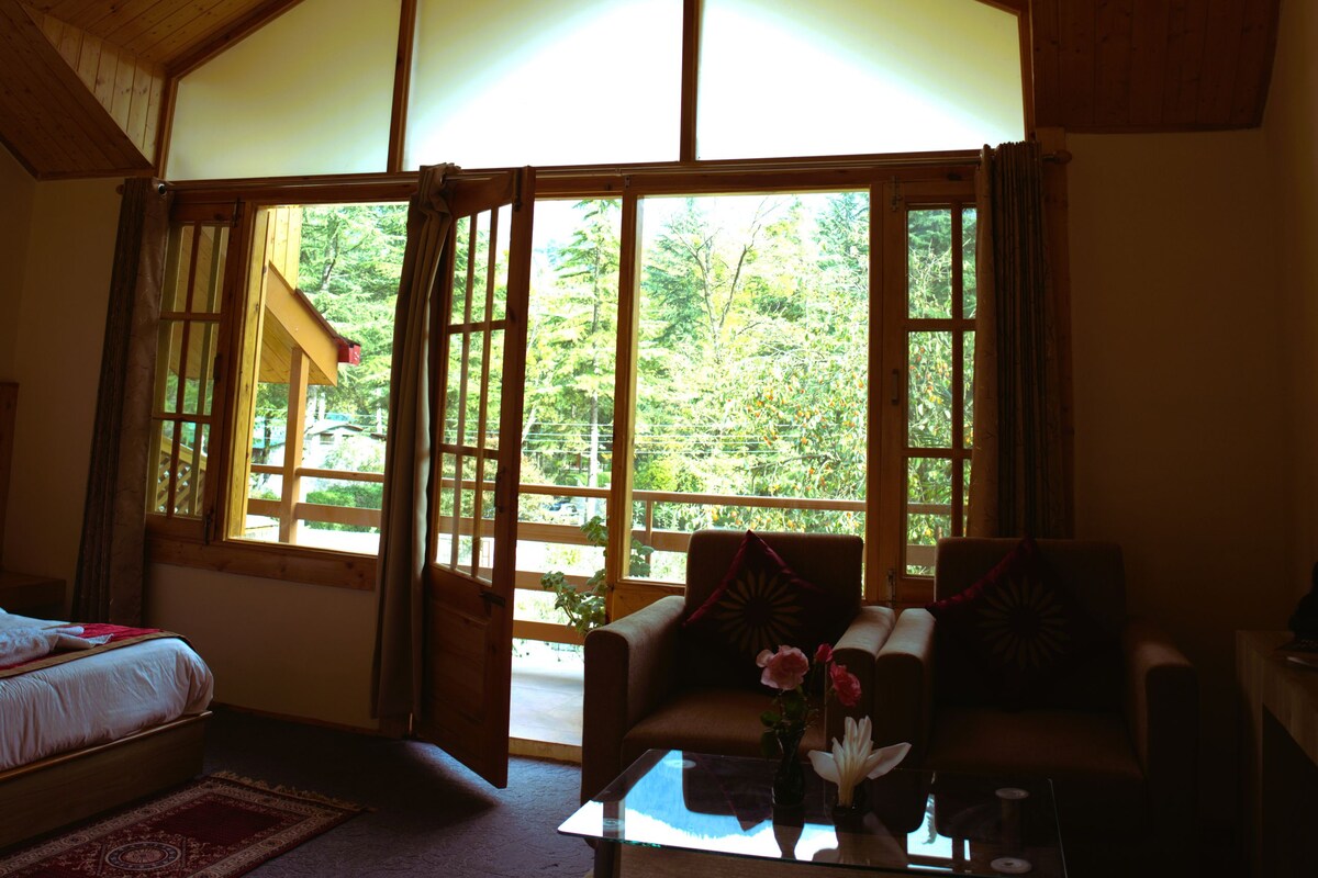 A room with a large window, a bed, a sofa, and a coffee table.