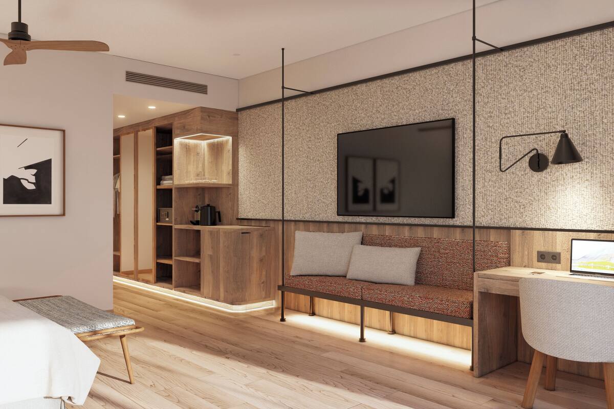 Un dormitorio moderno con cama, escritorio, sofá y televisor.