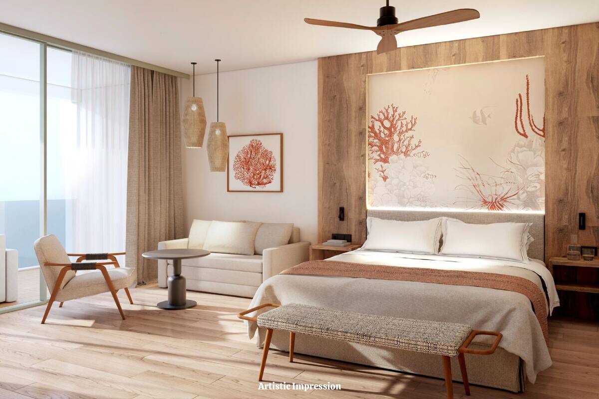 Una habitación de hotel moderna con una cama grande, una zona de estar con sofá y sillones, una mesa de comedor y un amplio ventanal con cortinas.