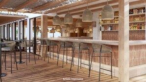Zona de bar con vigas de madera, lámparas colgantes de tejido y una barra con taburetes.