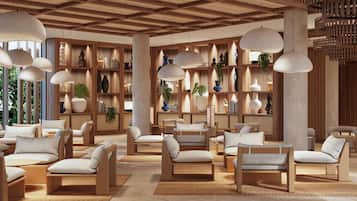 Een moderne zithoek met houten meubels, hanglampen en diverse decoratieve items op planken.
