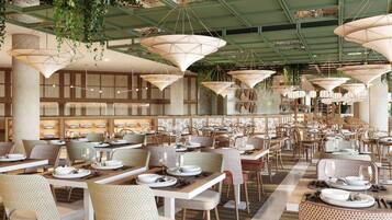 Un restaurant espaiós amb sostres alts, plantes penjants i diferents disposicions de seients.