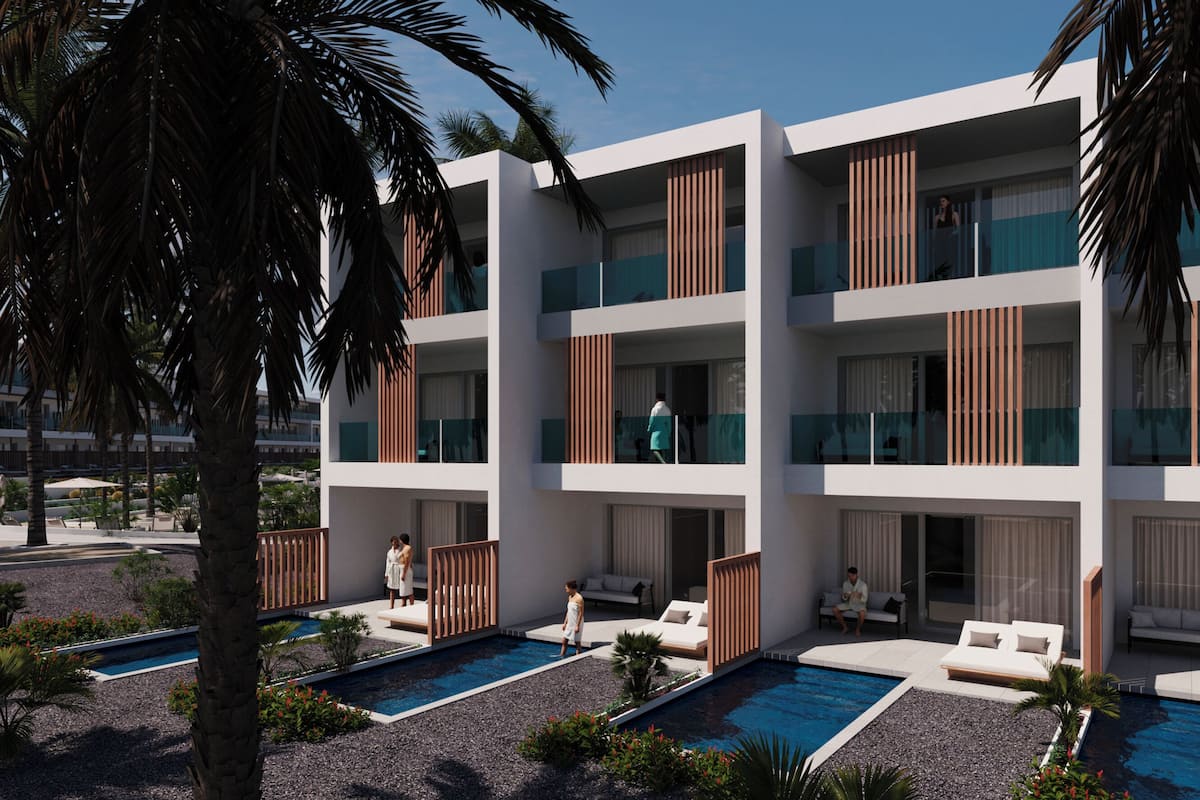A modern hotel with multiple balconies, a swimming pool, and outdoor seating areas.