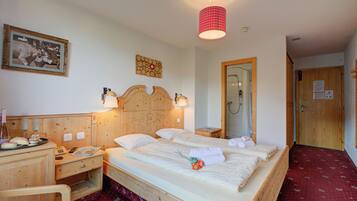 Una camera d'albergo con un letto di legno, comodini, uno specchio e una moquette rossa.