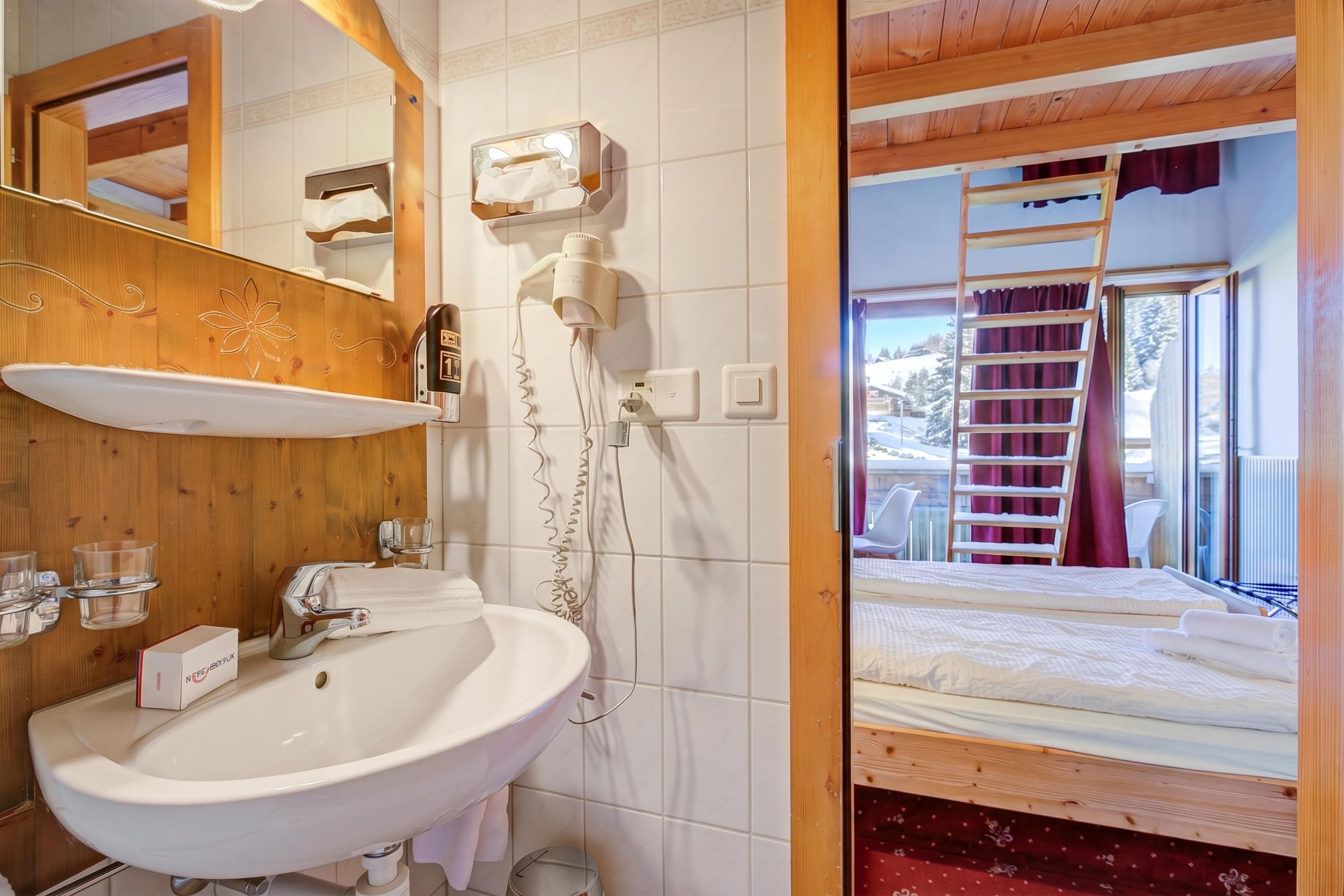 A bathroom with a wooden vanity, a sink, and a mirror.