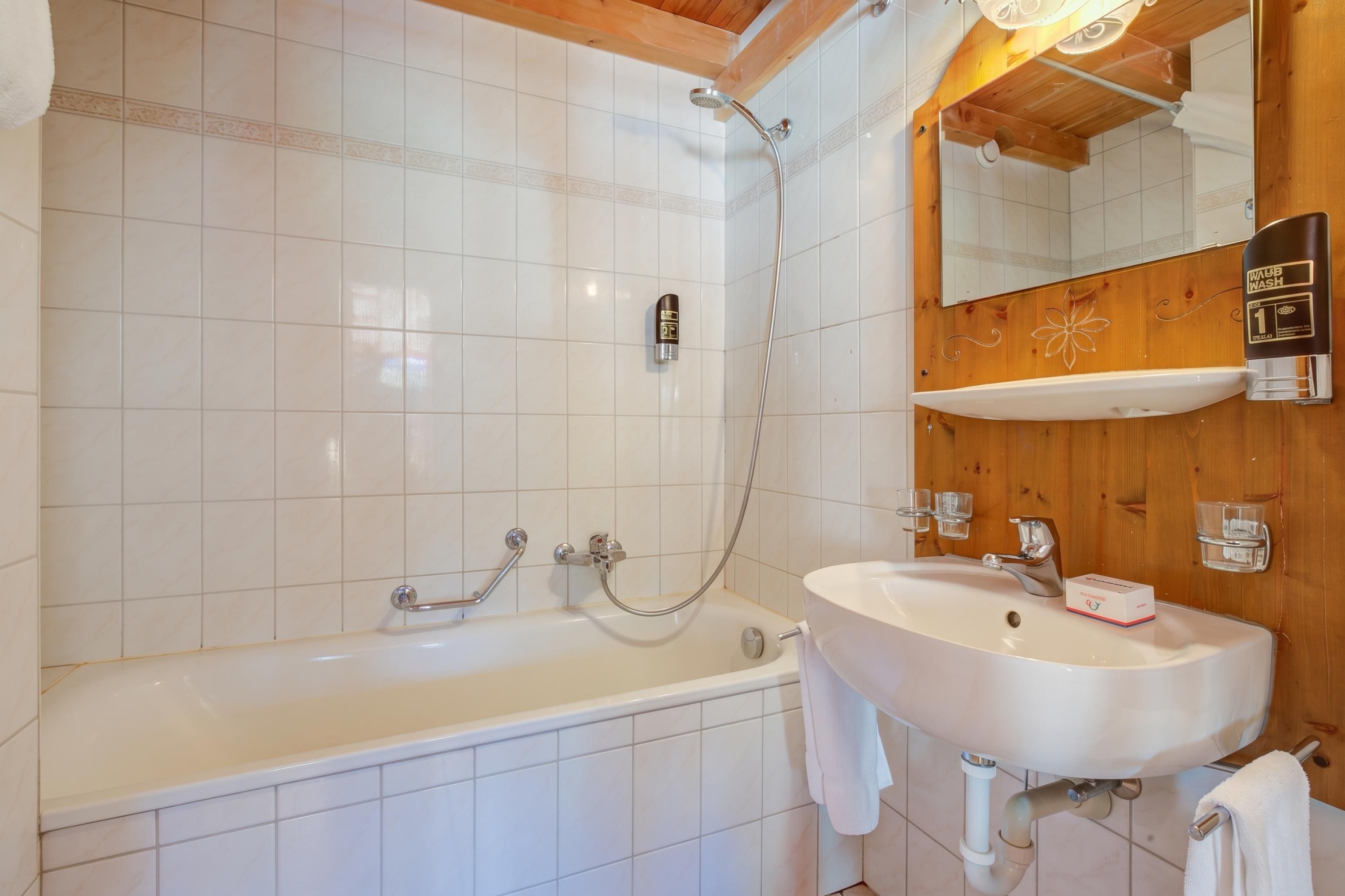 Ein Badezimmer mit einer Badewanne, einem Waschbecken und einer Dusche.