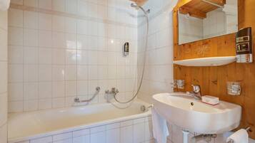 Ein Badezimmer mit einer Badewanne, einem Waschbecken und einer Dusche.