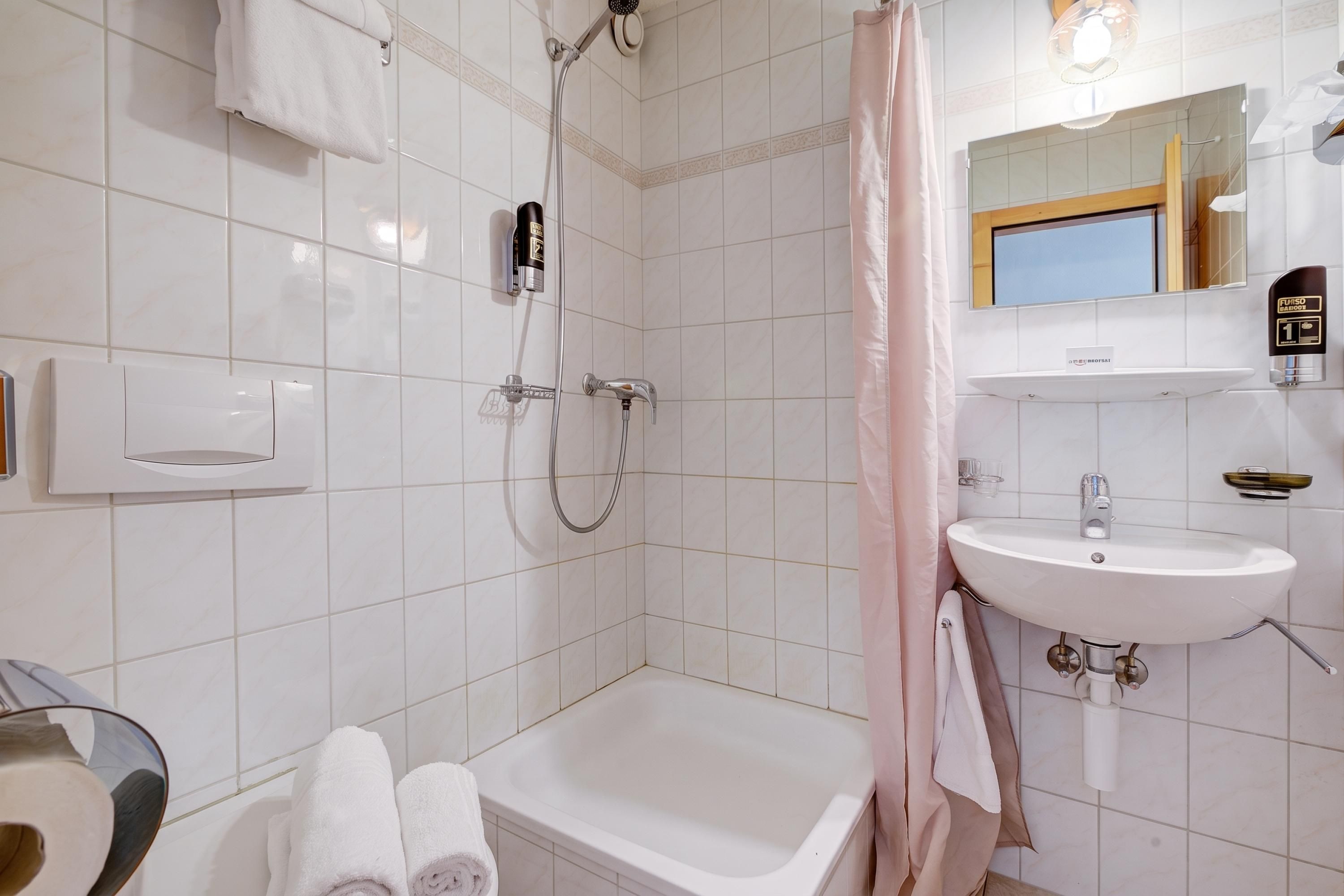 Ein modernes Badezimmer mit Badewanne, Dusche und Waschbecken.