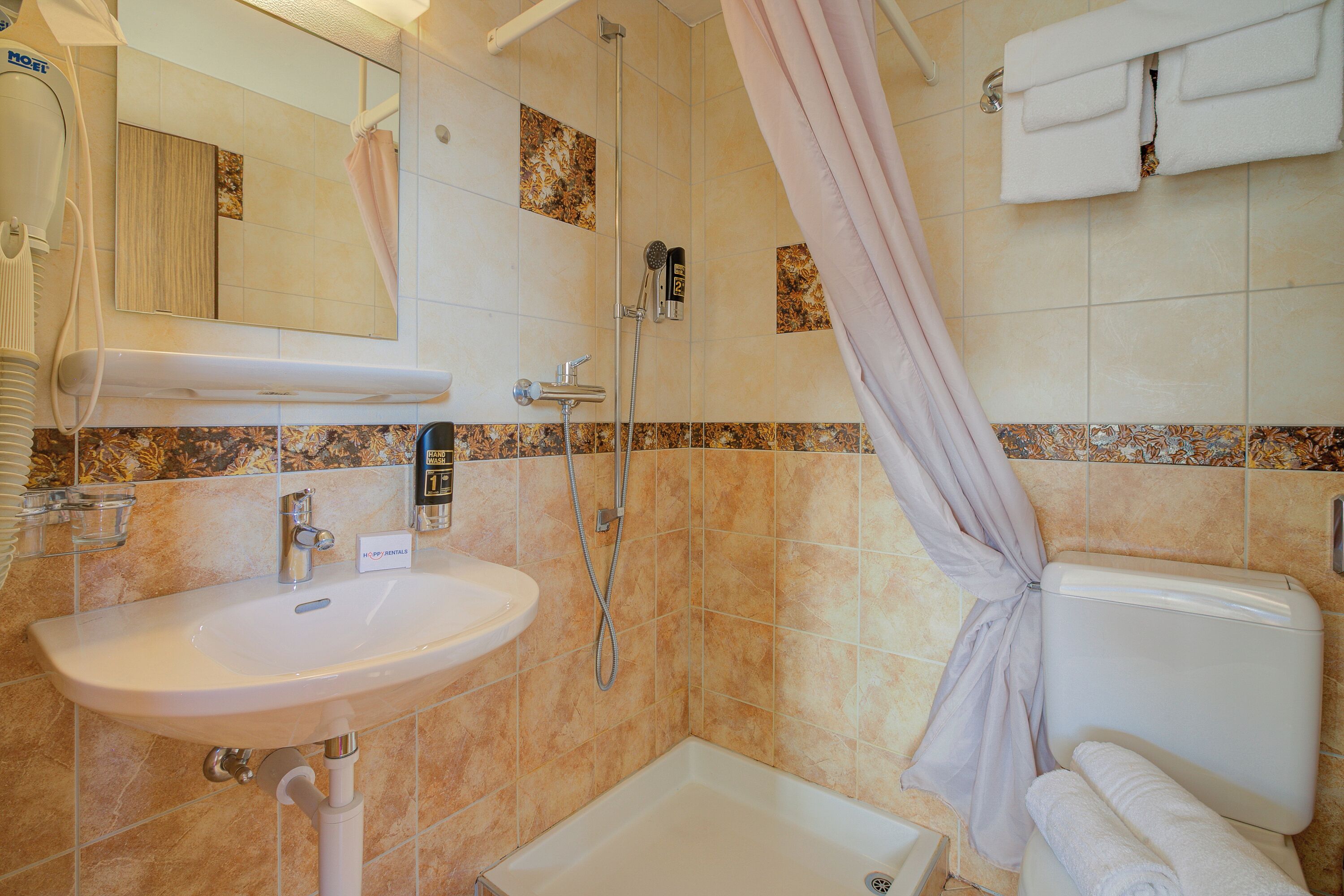 Ein Badezimmer mit Waschbecken, Dusche und Toilette.