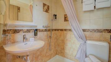 Ein Badezimmer mit Waschbecken, Dusche und Toilette.